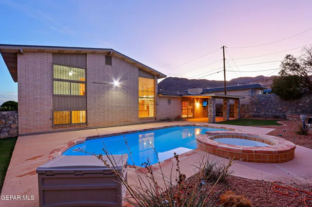 a view of a house with swimming pool and sitting area