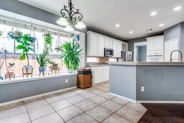 a kitchen with kitchen island white cabinets a sink a window and appliances
