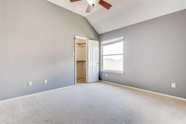 an empty room with a window and a ceiling fan