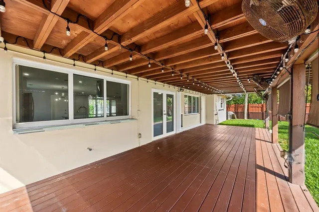 an empty room with a window and a ceiling fan
