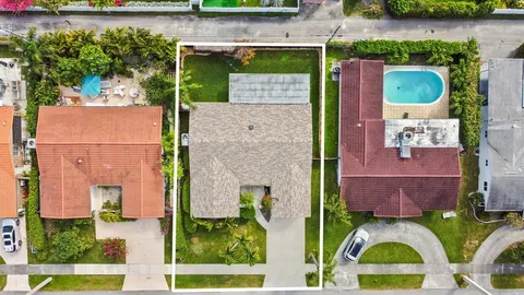 an aerial view of a house with a yard and large trees