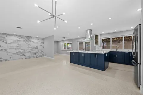 a large kitchen with stainless steel appliances granite countertop a large counter top and a stove