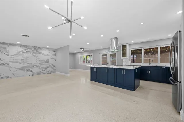 a large kitchen with stainless steel appliances granite countertop a large counter top and a stove