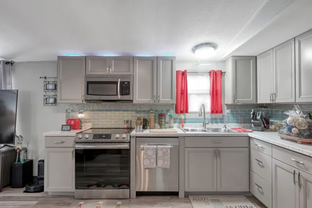 a kitchen with stainless steel appliances a sink stove and cabinets