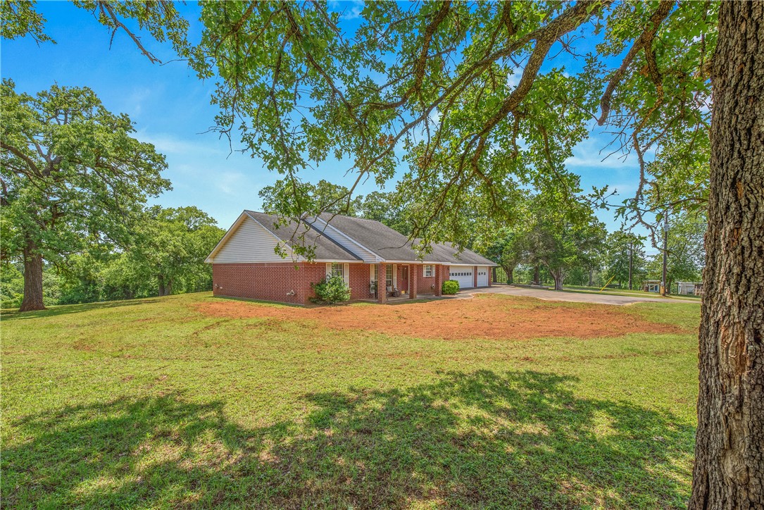 1110 County Road 439 Dime Box, TX 77853 - Photo 5 of 50 a tall yellow house with a big yard plants and large trees