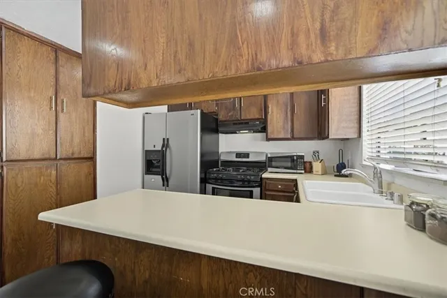 a kitchen with stainless steel appliances a refrigerator a sink a stove a microwave and cabinets