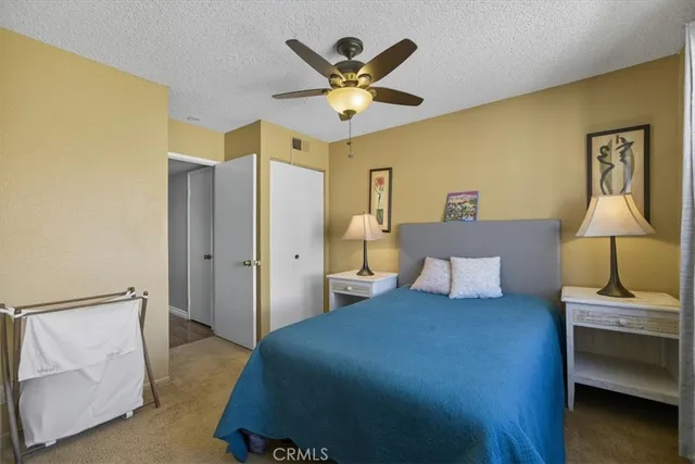 a bed room with a bed and a ceiling fan