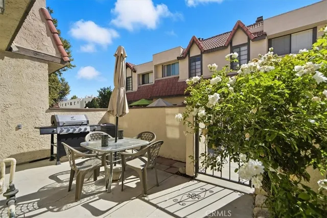 a view of a patio with table and chairs under an umbrella