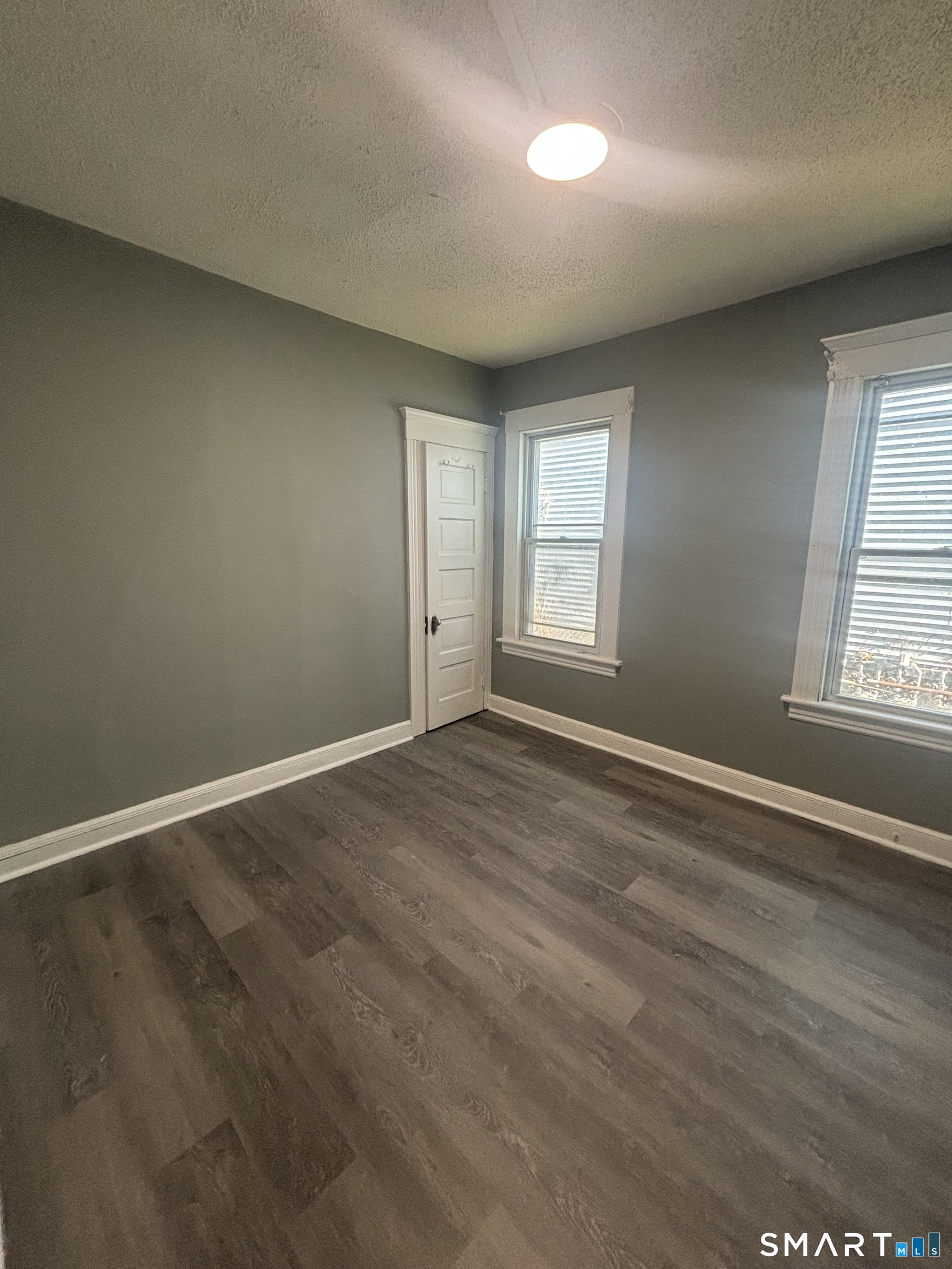 473 Putnam Street Bridgeport, CT 06608 - Photo 5 of 7 an empty room with wooden floor and windows