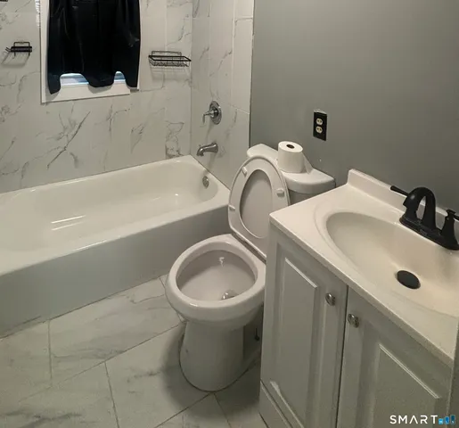 a bathroom with a toilet a sink and bathtub