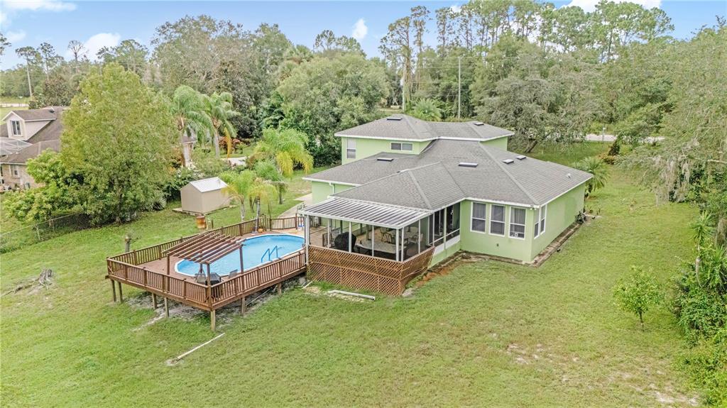 2060 Doyle Road Deltona, FL 32738 - Photo 41 of 43 a view of a house with a big yard and large trees