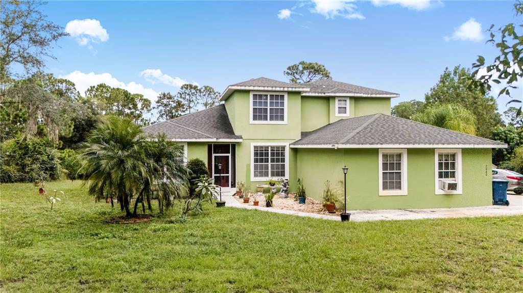 2060 Doyle Road Deltona, FL 32738 - Photo 5 of 43 a front view of a house with a garden