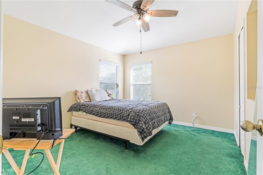 2060 Doyle Road Deltona, FL 32738 - Photo 6 of 43 a spacious bedroom with a bed and a chandelier