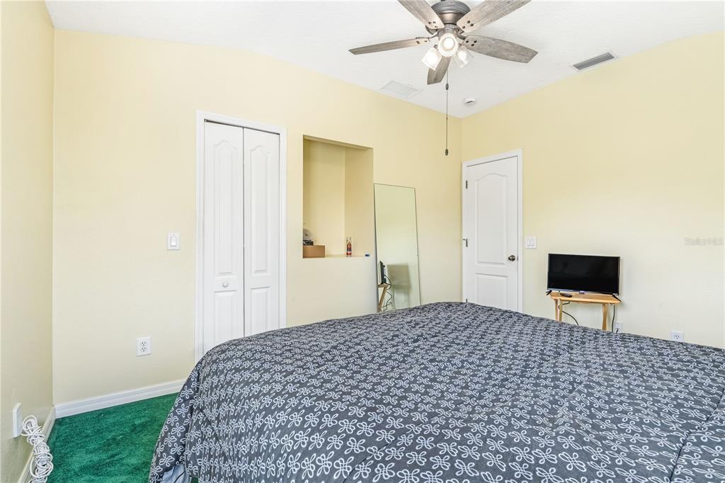 2060 Doyle Road Deltona, FL 32738 - Photo 7 of 43 a bedroom with a bed and a chandelier