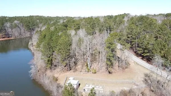 an aerial view of a house with a yard and lake view
