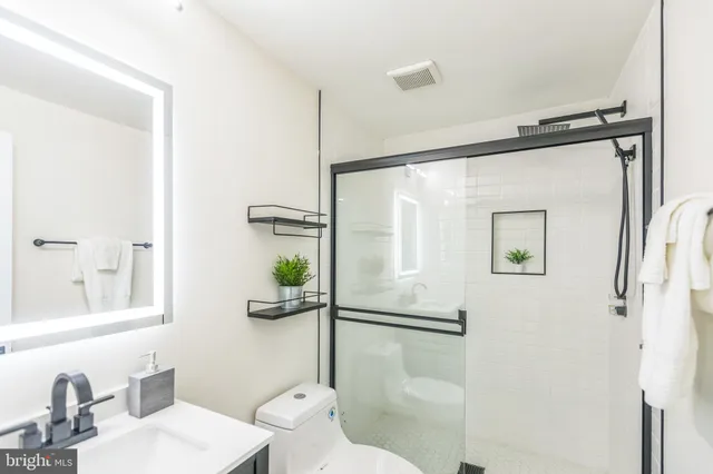 a bathroom with a sink mirror toilet and shower