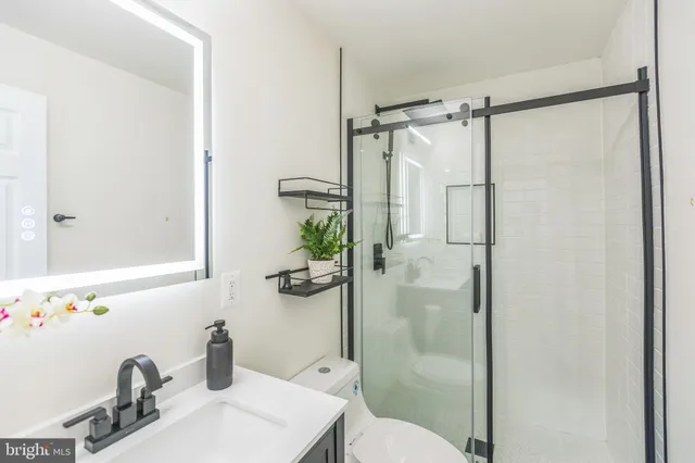 a bathroom with a sink mirror toilet and shower