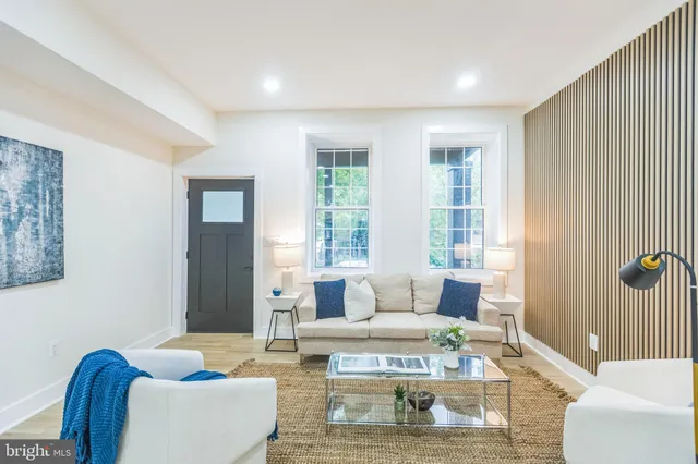 a living room with furniture wooden floor and a window