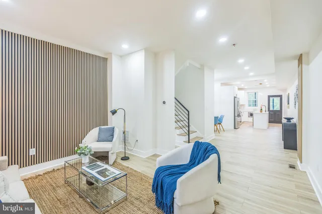 a living room with furniture a rug and white walls