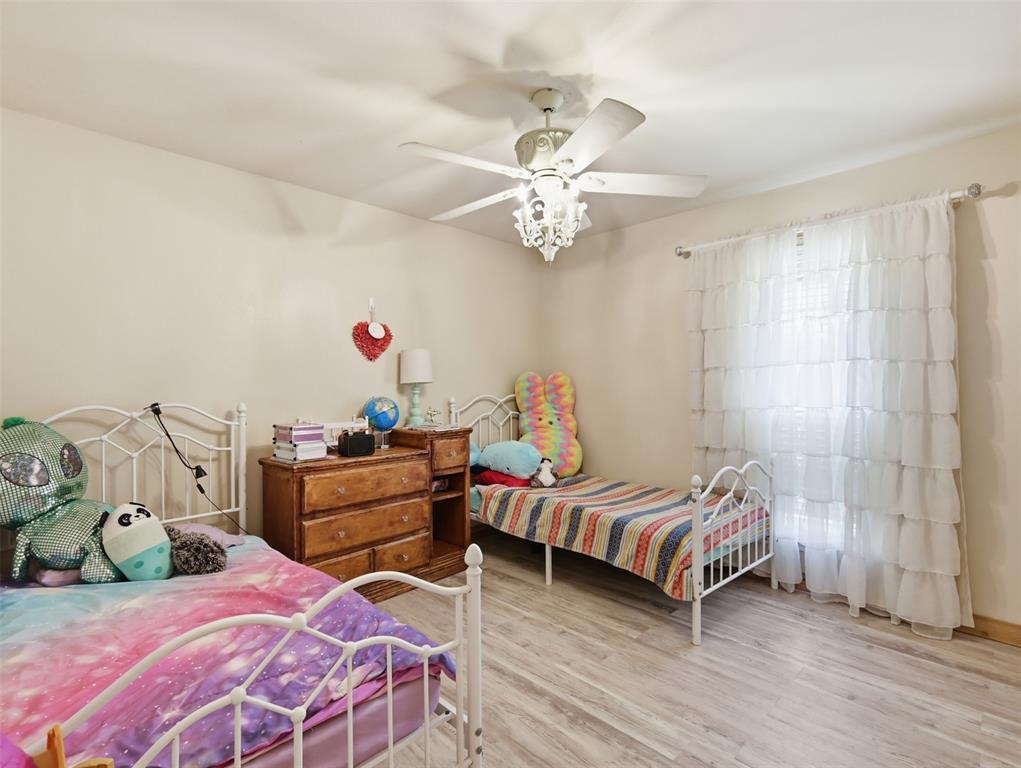 3823 State Highway Bonham, TX 75418 - Photo 28 of 37 a bedroom with a bed and a chandelier