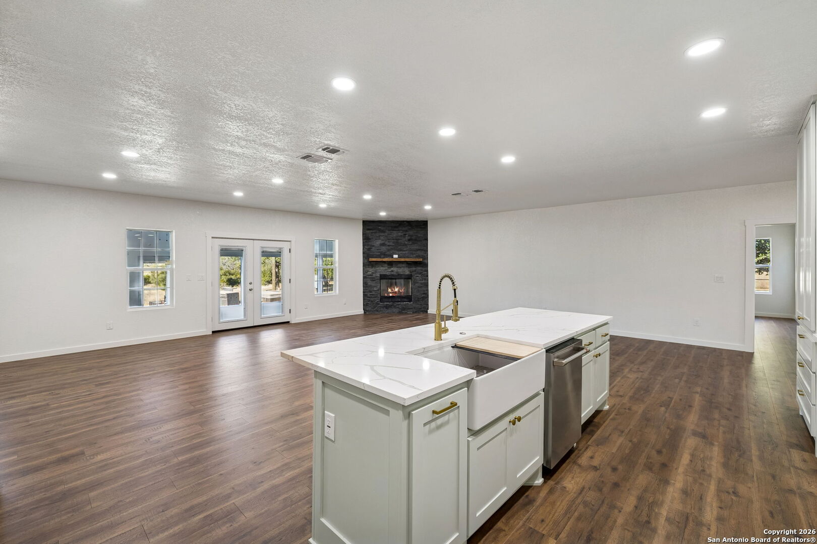 11890 Ranch Road 965 Fredericksburg, TX 78624 - Photo 17 of 40 a kitchen that has a sink a stove and wooden floor