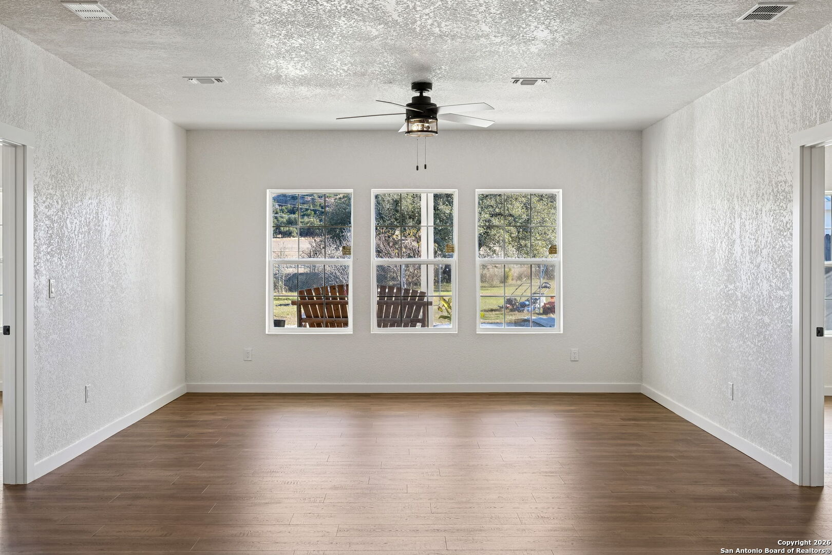11890 Ranch Road 965 Fredericksburg, TX 78624 - Photo 26 of 40 a view of an empty room with wooden floor and a window