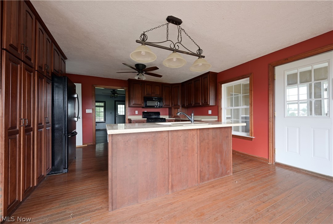 19105 Whitehead Road Lagrange, OH 44050 - Photo 23 of 37 Kitchen with a wealth of natural light, ceiling fan, black appliances, and hardwood / wood-style floors