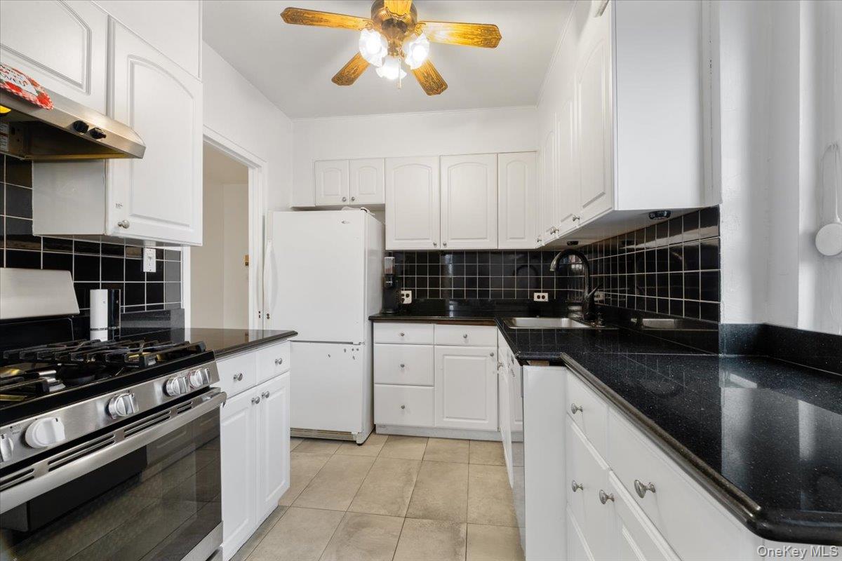 190 Garth Road, Unit 3R Scarsdale, NY 10583 - Photo 11 of 31 a kitchen with a sink a stove and cabinets