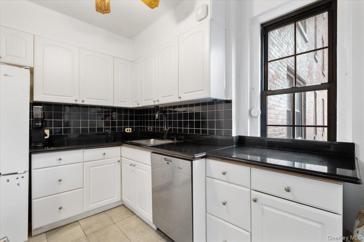 190 Garth Road, Unit 3R Scarsdale, NY 10583 - Photo 12 of 31 a kitchen with granite countertop a sink and a white cabinets