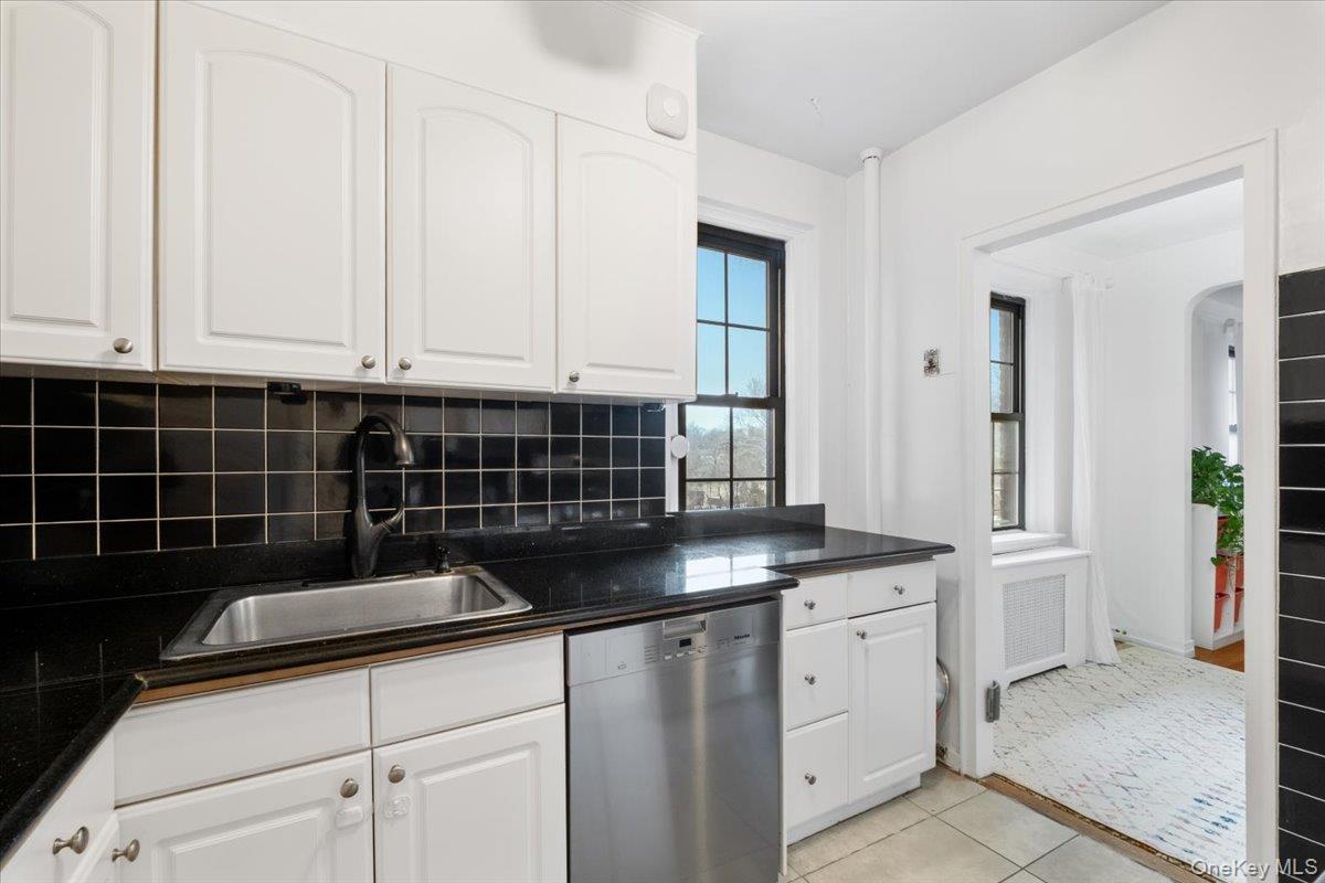 190 Garth Road, Unit 3R Scarsdale, NY 10583 - Photo 14 of 31 a kitchen with white cabinets and sink