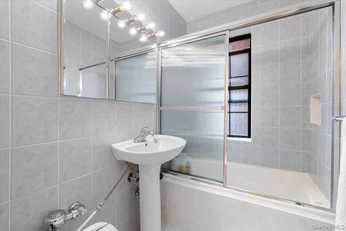 190 Garth Road, Unit 3R Scarsdale, NY 10583 - Photo 20 of 31 a bathroom with a sink a mirror and a shower