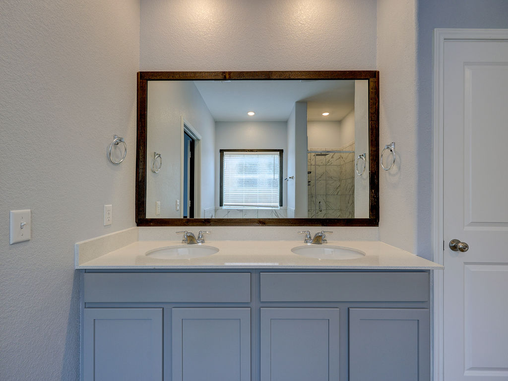 1716 Frontenac Street Leander, TX 78641 - Photo 20 of 34 a bathroom with a sink and two mirror