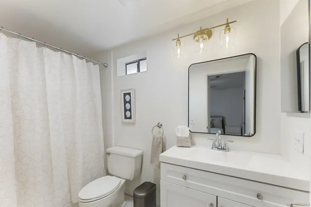 a bathroom with a toilet a sink and a mirror