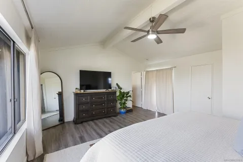 a bedroom with a bed and a flat screen tv