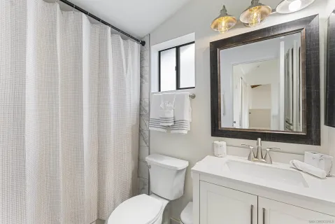 a bathroom with a sink vanity mirror and toilet