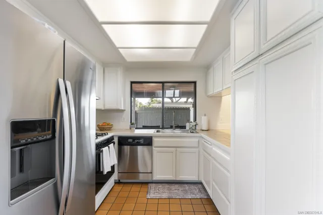 a kitchen with a sink stainless steel appliances a window and a counter top space
