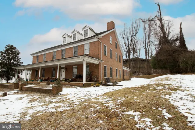 a front view of a building with snow on the side of road