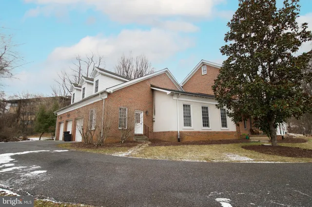 a view of a white house next to a road and yard