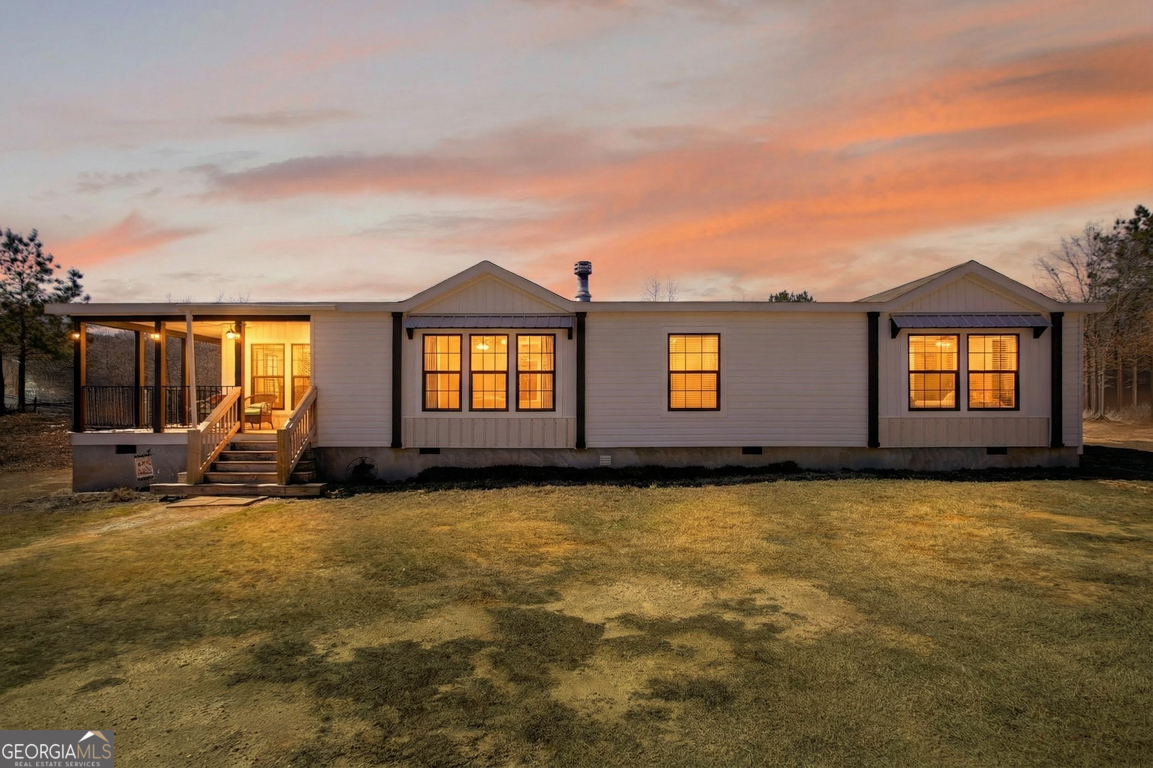 a view of a large pool with lawn chairs under an umbrella