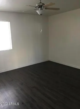 a view of a room with wooden floor and a window