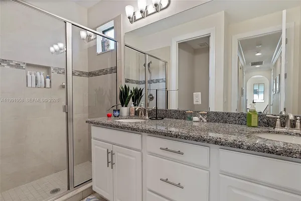 a bathroom with a granite countertop sink mirror and shower