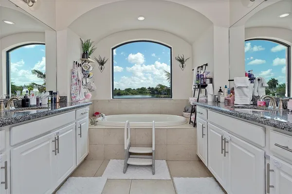 a bathroom with a double vanity sink a mirror and a bathtub