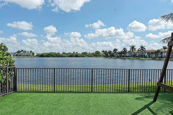 a view of a yard with a lake view and wooden fence
