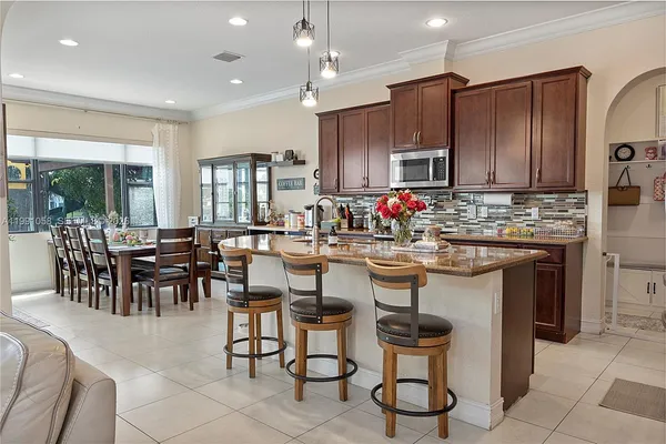 a kitchen with living room and chairs