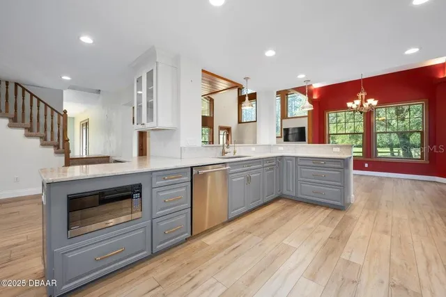 a kitchen with stainless steel appliances granite countertop a stove a sink and a microwave
