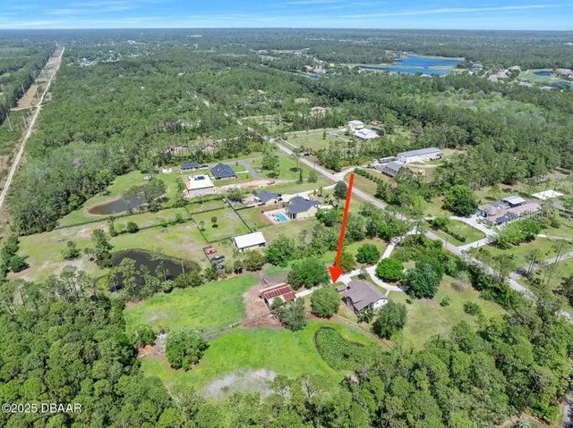 an aerial view of residential houses with outdoor space and trees