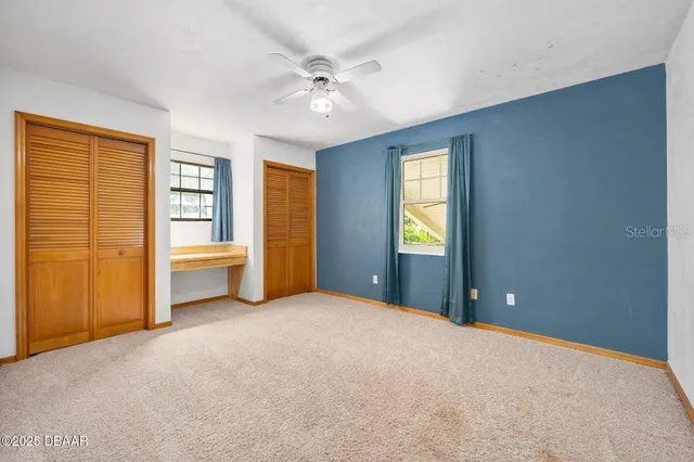 a view of a room with cabinet and a ceiling fan