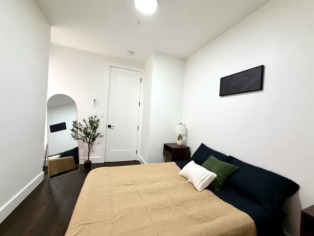 a bedroom with a bed and a potted plant