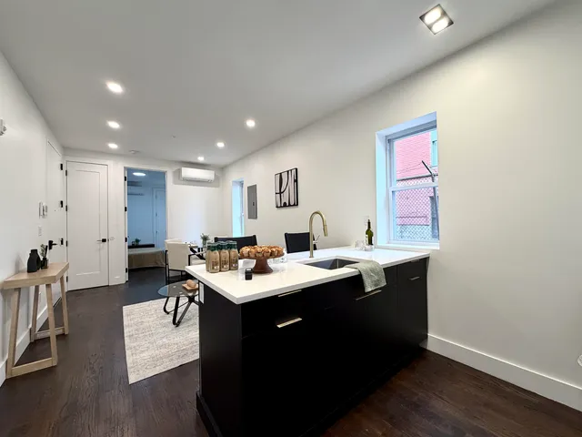 a room with furniture a sink dishwasher and a dining table with wooden floor