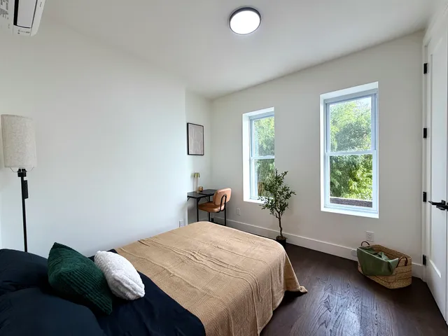 a bed sitting in a bedroom next to a window
